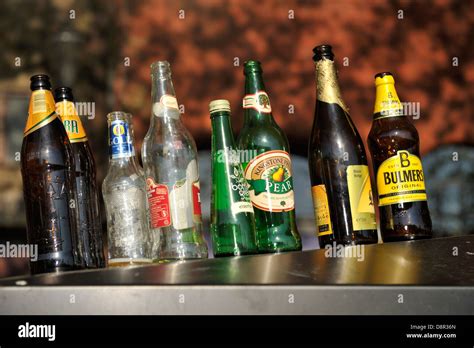 Empty Drinks Bottles Lined Up On Top Of Recycling Container Outside