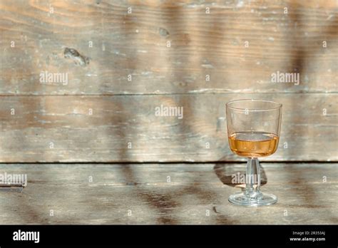 Liquor In A Transparent Drinking Glass Isolated On A Textured Wooden