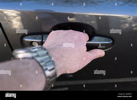 closeup   mans hand holding  car door handle  unlocking  car