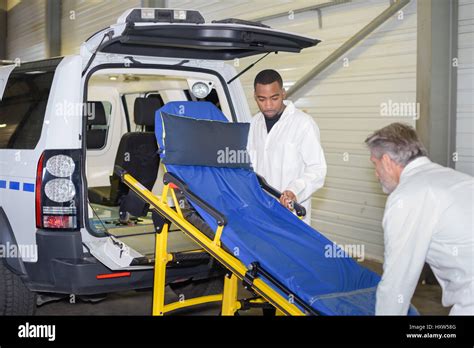 Paramedics Loading Stretcher Into Emergency Vehicle Stock Photo Alamy