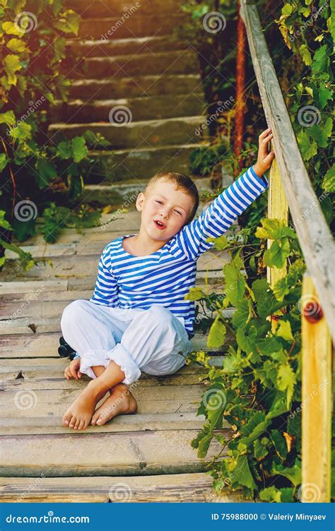 Bello Ragazzo Gay Che Posa Su Una Scala Di Legno Vestito In Uno Stile Nautico Fotografia Stock