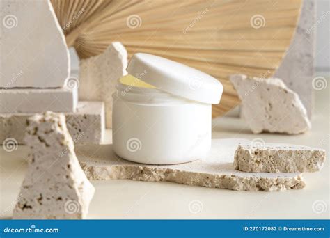 Opened White Cream Jar With A Lid On Biege Stones Against Dried Palm