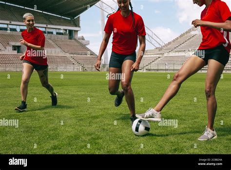 Group of women playing football on the field running for the ball ...