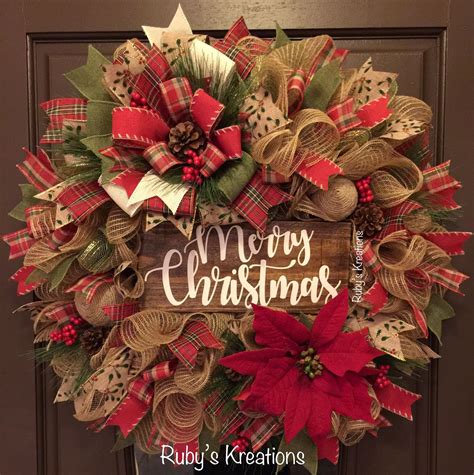 a christmas wreath with red and green poinsettis hanging on the front door