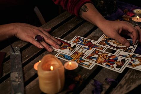 La Pitonisa Lee Las Cartas Del Tarot En Una Mesa Con Velas Foto Premium