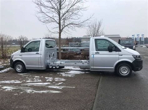 Two Silver Vans Parked Next To Each Other In A Parking Lot With Snow On