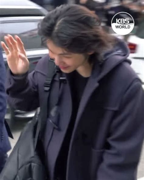 A Woman Walking Down The Street With Her Hand Up