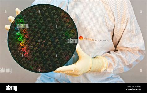 An Employee Holds A 300mm Large Chip Wafer In His Hands While The