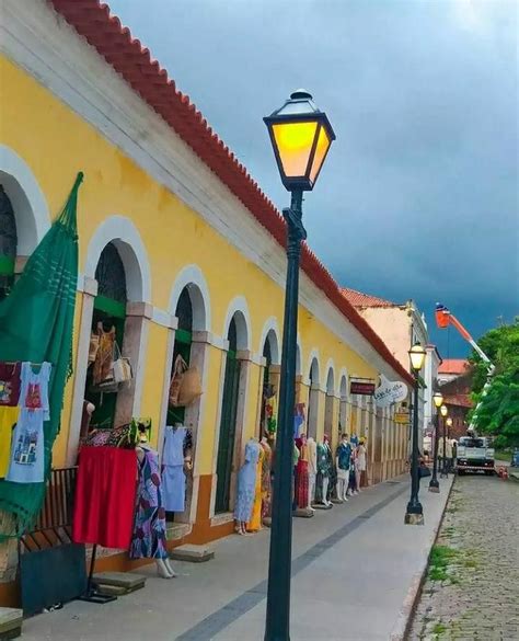 People Are Walking Down The Street In Front Of Buildings With Flags