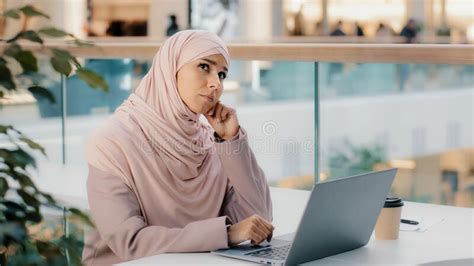 Thoughtful Pensive Worried Young Arab Woman Writer Working On Laptop