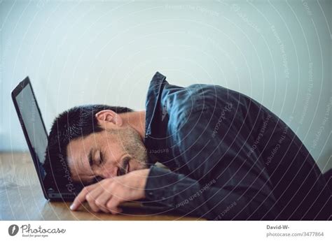 Businessman In Suit Lying On A Couch With Two Cellphones And Laptops