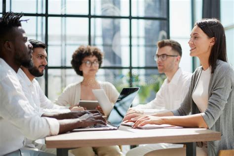 Employees Working At Computer Together Discussing Content Stock Image