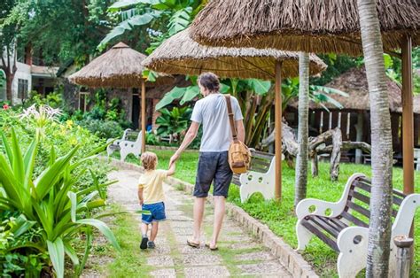 Feliz Joven Padre De La Mano De Su Peque O Hijo Y Caminando En La