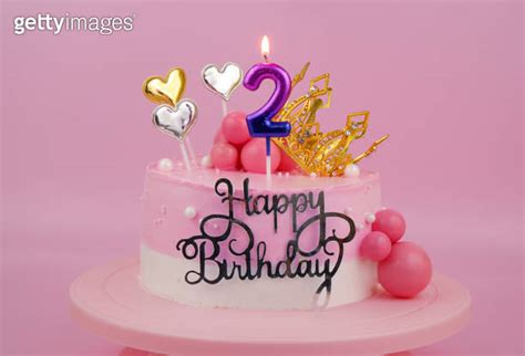 Pink Birthday Cake With Gold Crown And Burning Candles Number