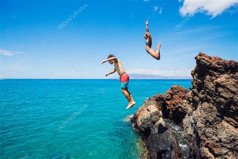 Friends Cliff Jumping Into The Ocean — Stock Photo © Epicstockmedia