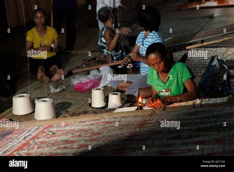 A Woman Working With Patterns On The Side Of A Traditional Woven Fabric