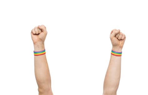 Premium Photo Hands With Gay Pride Rainbow Wristbands Shows Fist