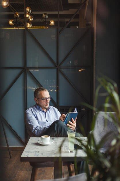 Premium Photo Man Using Mobile Phone While Sitting On Table