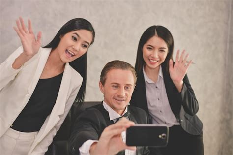 Un Hombre De Negocios Sonriente Hablando De Selfie Con Sus Colegas En