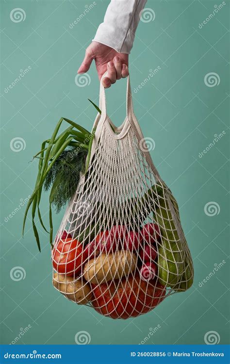 Bolsa De Malla Con Verduras Y Hierbas En Mano Hembra Foto De Archivo