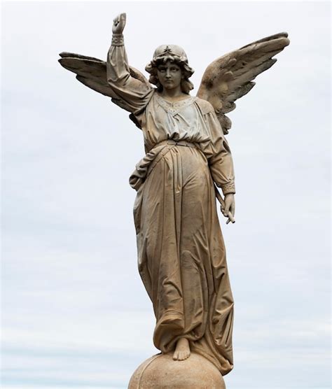 Una estatua de un ángel con una flecha en el centro de su mano Foto