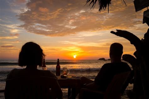 Premium Photo | Silhouette people sitting on beach during sunset