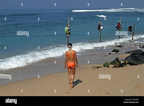 STILT FISHERMEN WOMAN IN BIKINI MIDIGAMA SRI LANKA 19 March 2013