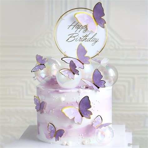 A White Cake With Purple Butterflies On It And A Happy Birthday Sign In