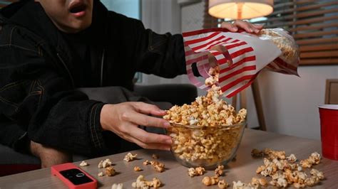 Premium Photo Young Man With Bowl Of Popcorn Watching Movie At Night