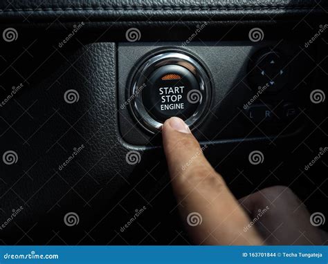 Start Stop Engine Button With Orange Light On Black Car Console