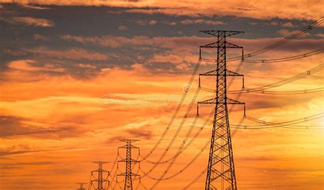 High Voltage Electric Pylon And Transmission Lines With Sunset Sky And