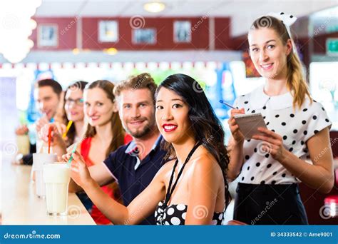 People In American Diner Or Restaurant With Milk Shakes Stock Photo