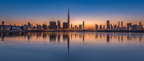 Mesmerizing Panorama Of Dubai City A Calm Sunset Reflecting On The