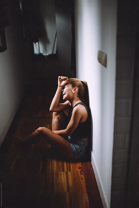 "Young Woman Sitting On A Corridor" by Stocksy Contributor "THAIS RAMOS