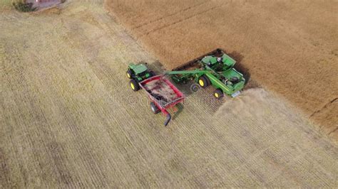 Aerial John Deere Combine Unloading Grain Into A Tractor Pulled Hopper