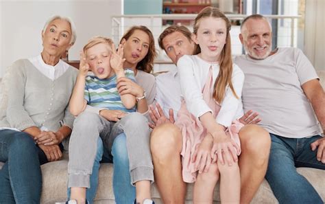 Retrato De Una Familia Feliz Sentada En El Sof Y Haciendo Muecas En La