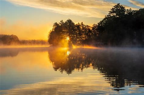 Premium Photo | Sunrise over a foggy lake