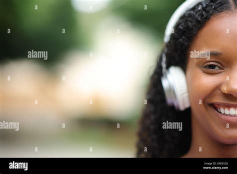 Front View Portrait Of A Face Of A Happy Black Woman Wearing Headphone