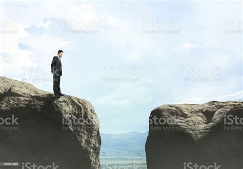 Businessman Looking At Gap Between Two Cliffs Stock Photo Download