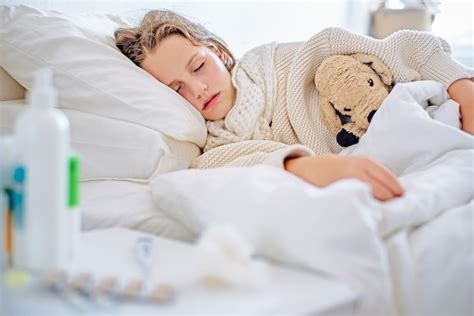 Une Jolie Petite Fille Dort Dans Un Lit Avec Un Ours En Peluche