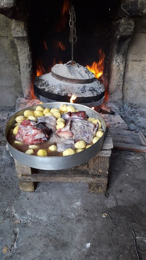 Two Pans Filled With Food Sitting In Front Of A Fire