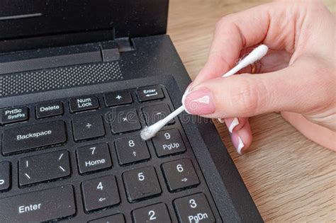 Cleans A Dusty And Dirty Laptop Keyboard With A Cotton Swab Stock