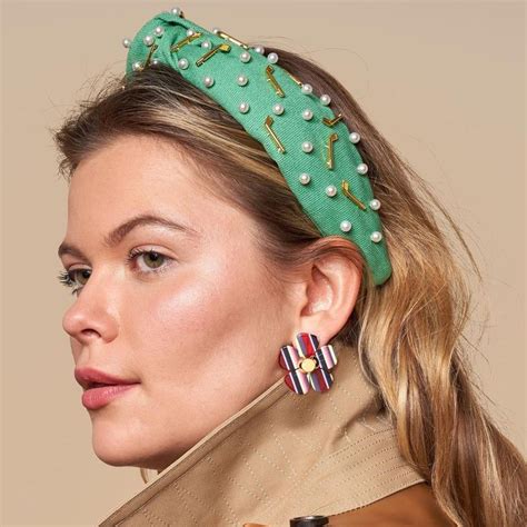 A Woman Wearing A Green Headband And Earrings