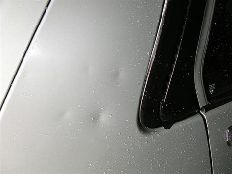 The Back Window Of A Car With Rain Drops On It