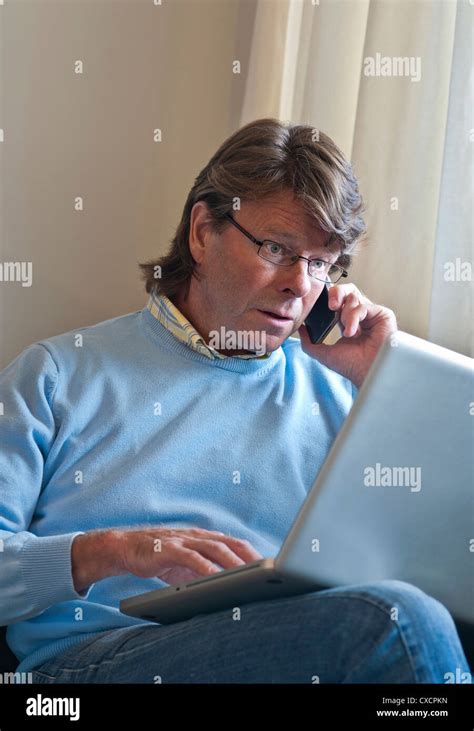 Worried Mature Man At Home Checking Screen Information On His Laptop