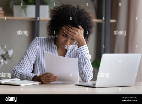 Unhappy African American Woman Reading Bad News In Letter Stock Photo