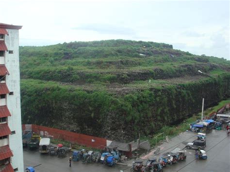 An Aerial View Of Cars Parked In Front Of A Large Hill