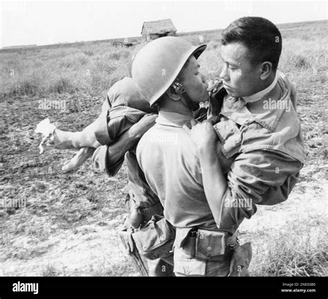 A Vietnamese Soldier Carries His Comrade From Battle After Government