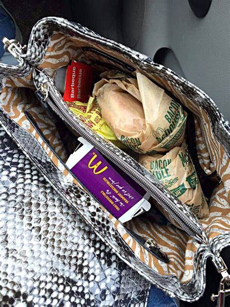 an open purse filled with food sitting on top of a seat in the back of ...