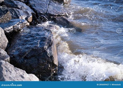 There Is A Rock Cliff Near The Ocean Shore And Some Water Stock Image